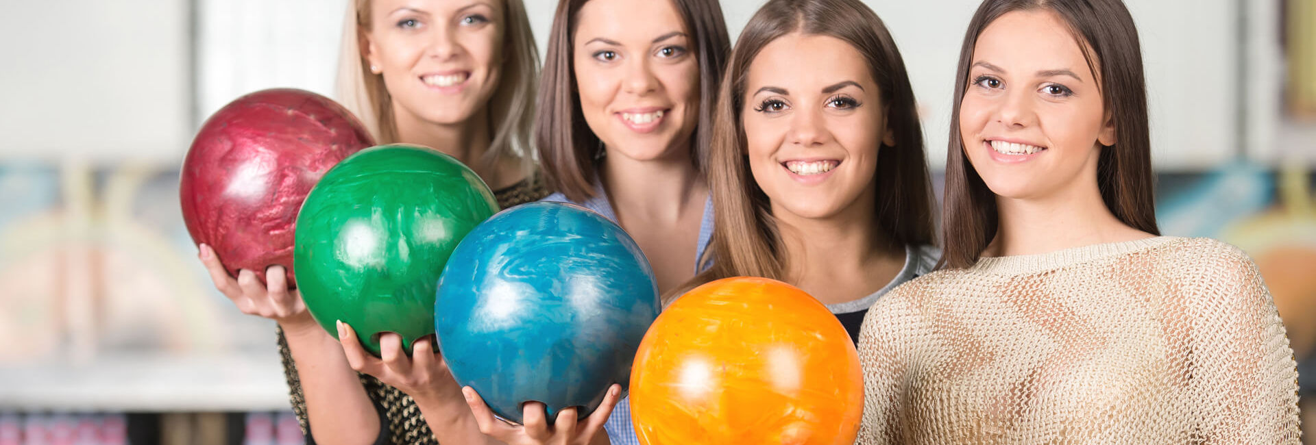 Vier schoolgaande meiden houden bowlingbal vast