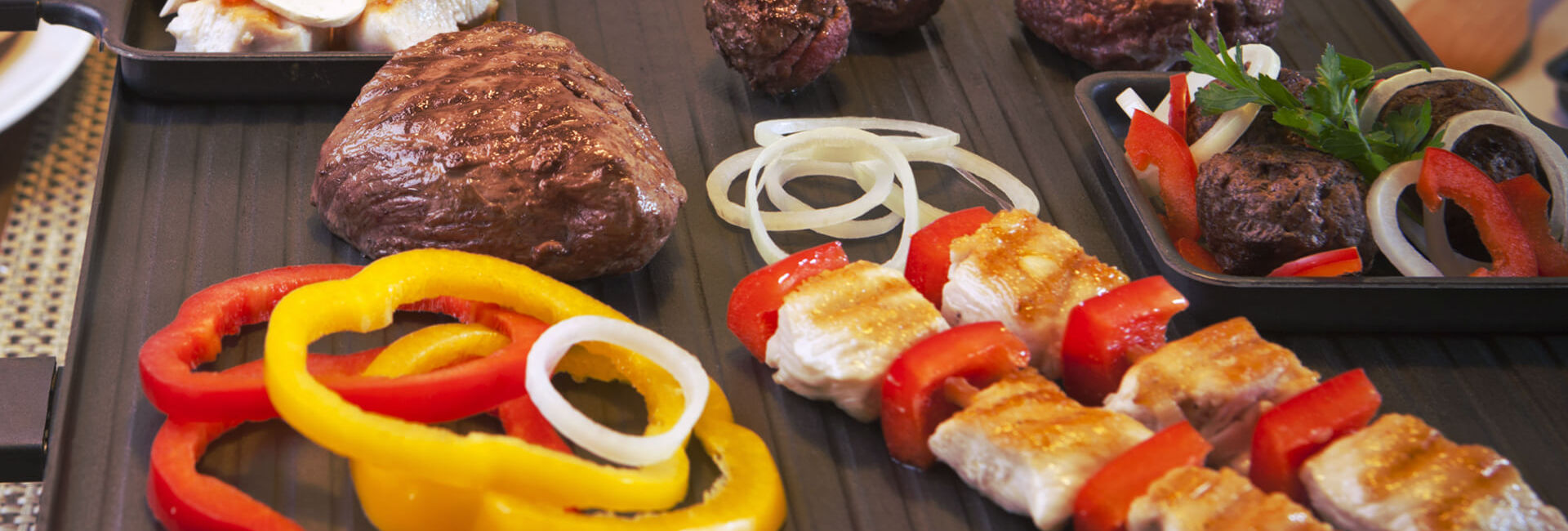 Gourmet plaat met vlees, ui en paprika als onderdeel van de Grill-Proeverij Combinatie